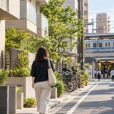 Resident walking along a Tokyo neighborhood street near a train station and apartments