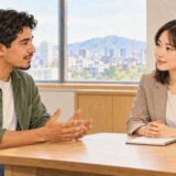 An employee talks privately with an HR staff member at a table in a Japanese office